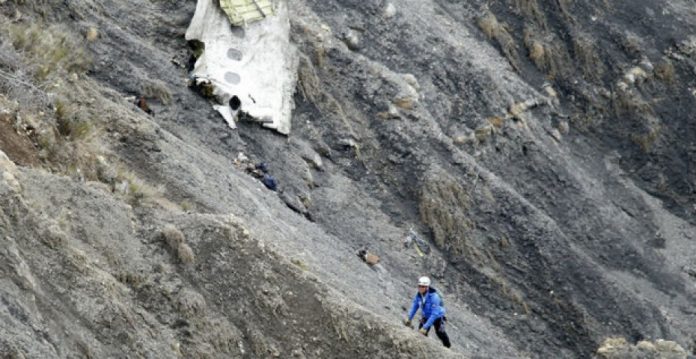 Un,miembro del servicio de rescate junto a un resto del fuselaje