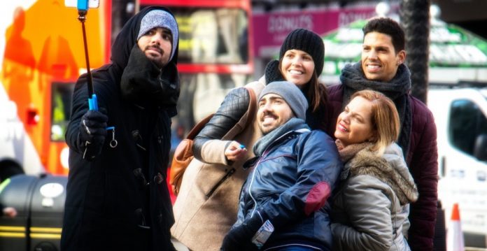 Gente realizando una fotografía con un palo para selfies