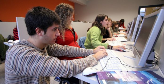 Alumnos en un aula TIC provista de ordenadores