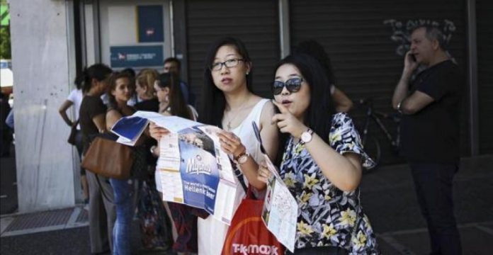 Varios turistas hacen cola en un cajero del Banco Nacional en Atenas