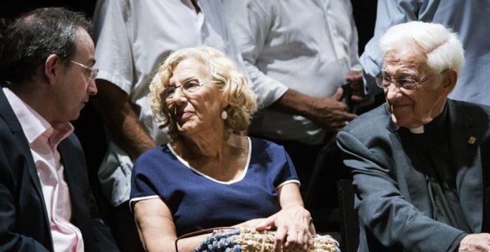 La alcaldesa de Madrid, Manuela Carmena, junto al padre Ángel (d), y el productor teatral Jesús Cimarro (i), ante el féretro de Lina Morgan.