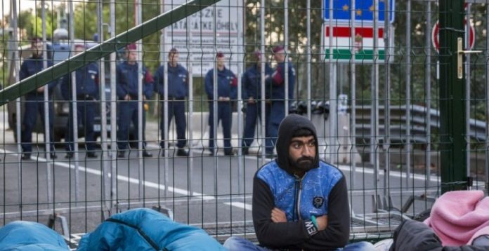 Un refugiado en la valla levantada en la frontera con Serbia