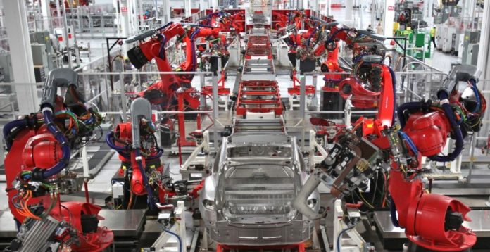 Línea de robots ensambladores en una fábrica de Tesla.